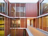 Vue sur la cour intérieure : des éléments coulissants en bois filigrane protègent du soleil